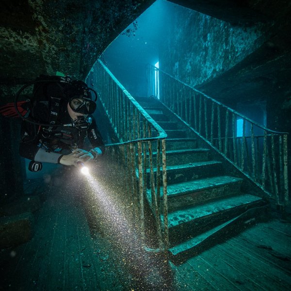 Taucherin die neben der berühmten Treppe des Wracks MS Karwela hertaucht. 