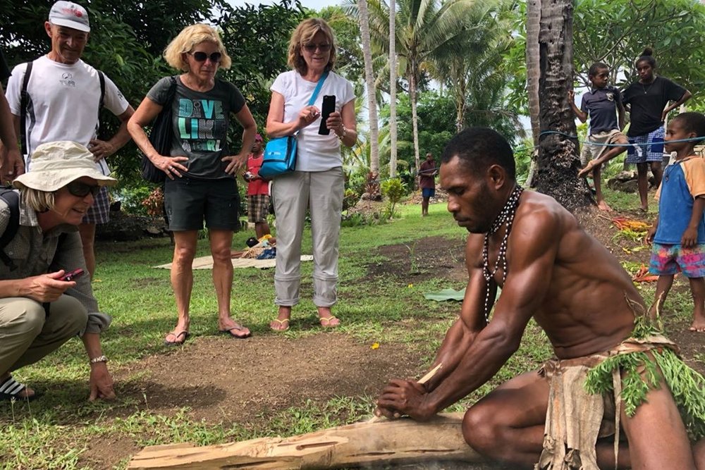 Indigenous person together with the tourists in the picture