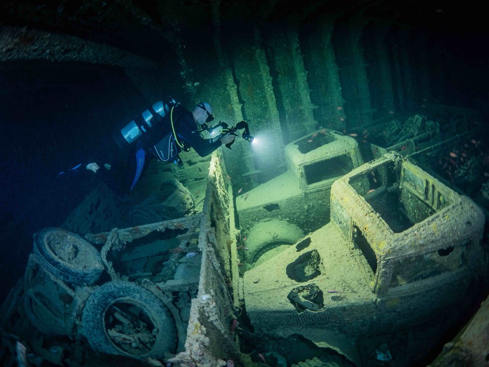 Photo of sunken trucks, divers and fish